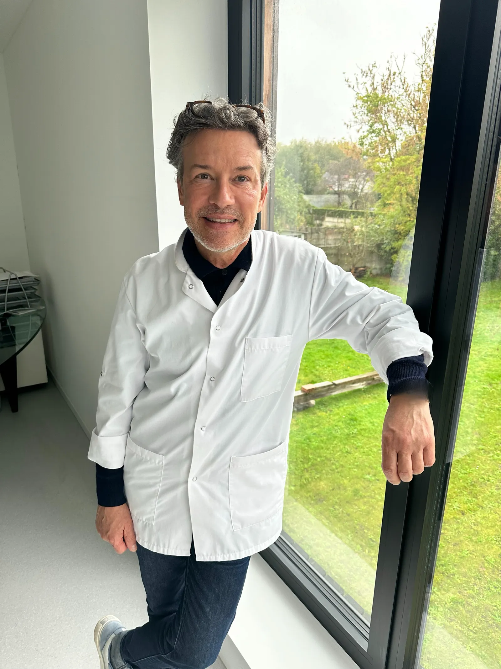 Le Dr Delaoustre appuyé à une fenêtre ouverte sur le jardin